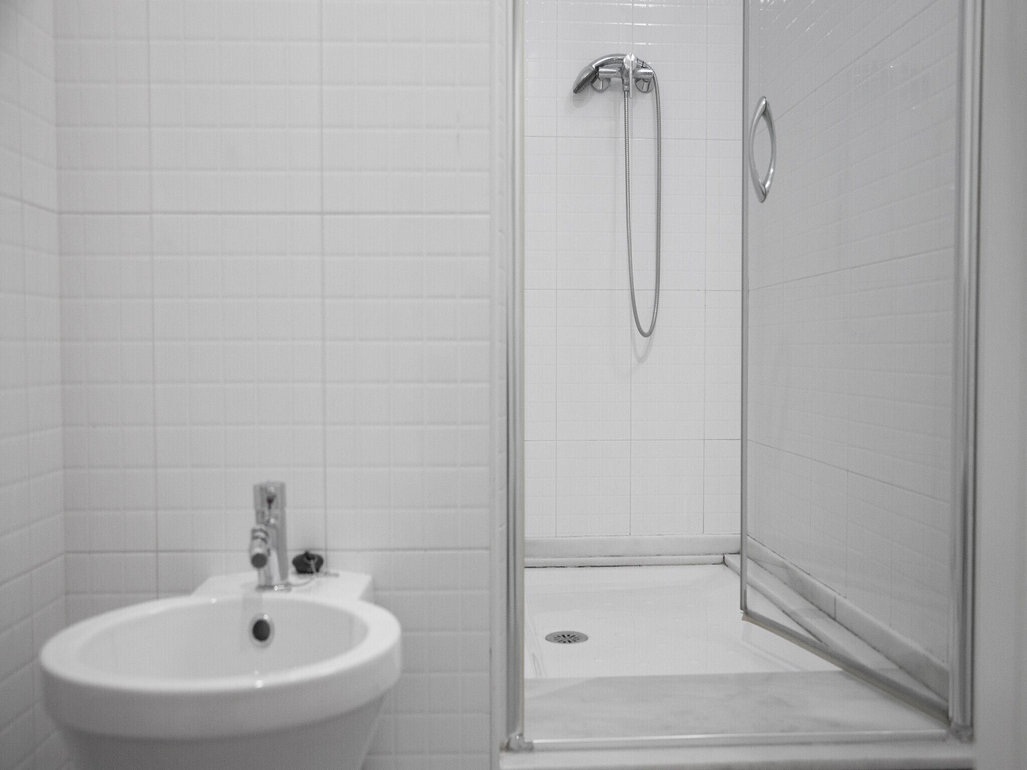 Un baño con lavamanos, ducha e inodoro.