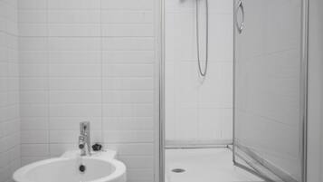 Un baño con lavamanos, ducha e inodoro.