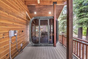 Eine Holzhütte mit einer Glastür, die auf eine Terrasse führt.