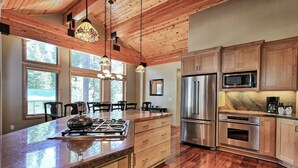 Una cocina moderna con armarios de madera, electrodomésticos de acero inoxidable y una isla grande con estufa a gas.
