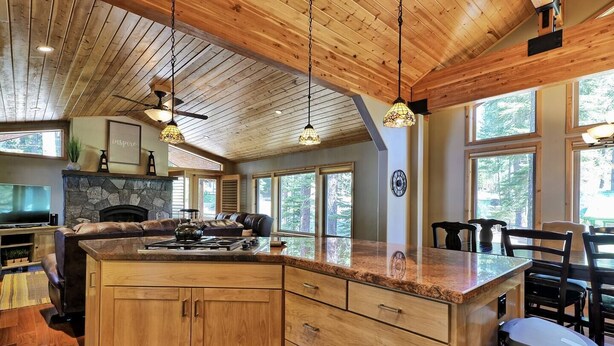 Una cocina amplia con una isla grande, armarios de madera e iluminación colgante.