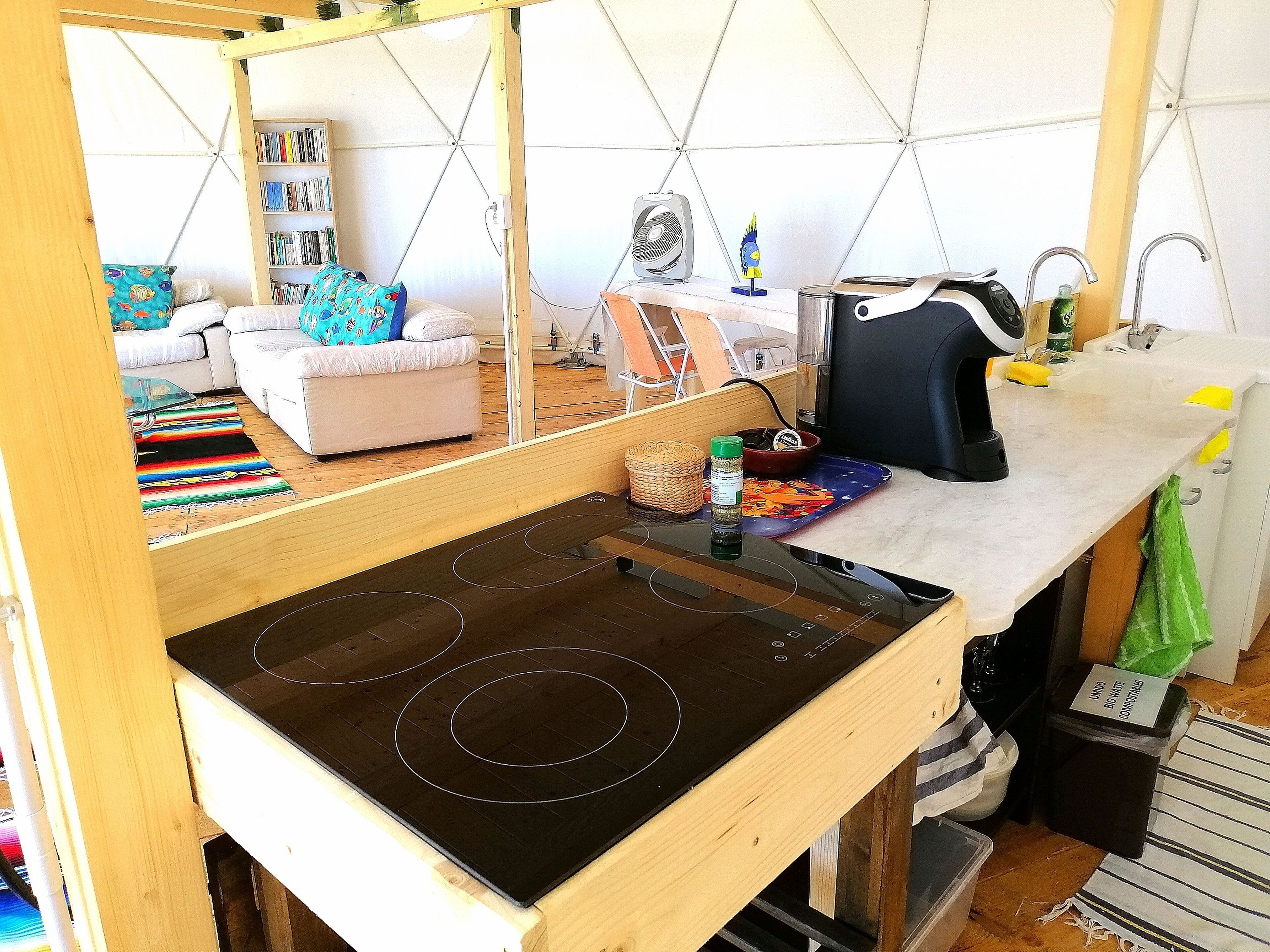 Une cuisine compacte dotée d’une cuisinière intégrée, d’un évier et d’un petit plan de travail.