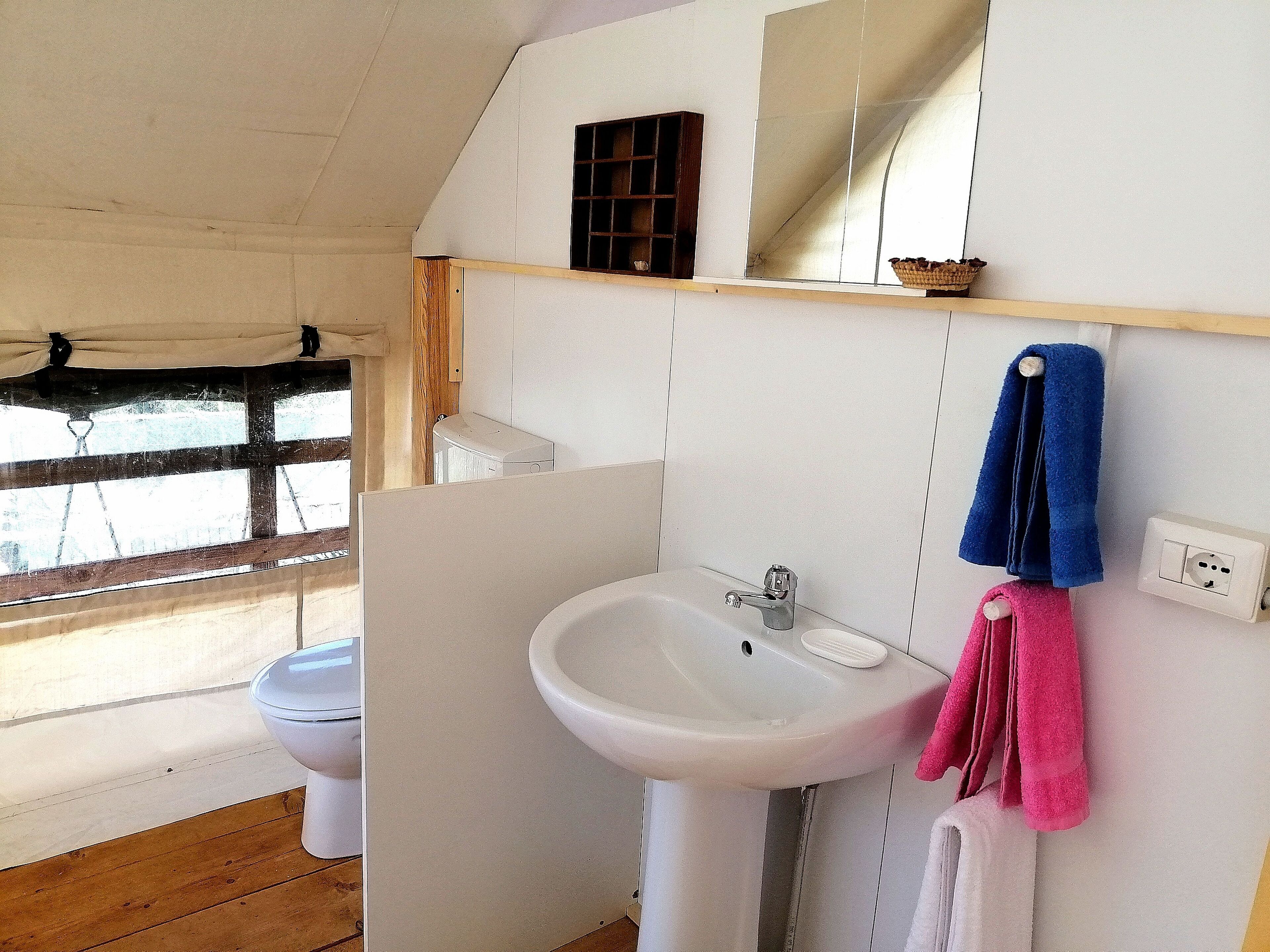 A bathroom with a white sink, a mirror, and a towel rack.