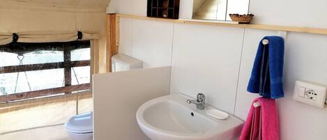 A bathroom with a white sink, a mirror, and a towel rack.