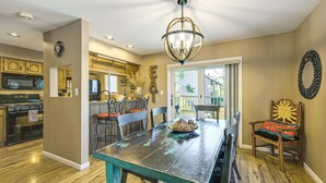 A kitchen with wooden cabinets, a dining table, and a chandelier.
