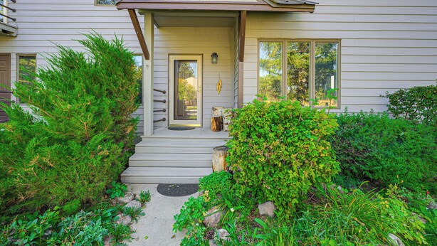 A two-story house with a front porch, a door, and windows.