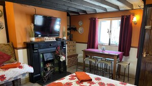 A cozy room with a bed, a fireplace, a television, and a dining area. - COTTAGE SLEEPING 4 HAYSTACK/HAYLOFT NEXT TO FOX COVERT PUB YARM (High Leven)