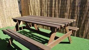 A wooden picnic table with benches, set on artificial grass, against a bamboo fence. - COTTAGE SLEEPING 4 HAYSTACK/HAYLOFT NEXT TO FOX COVERT PUB YARM (High Leven)