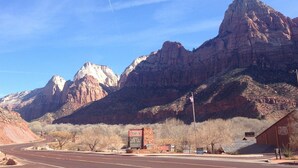 A road leading to a building with a sign indicating a market and a theater. - Apartment #3 GREAT LOCATION Zion National Park entrance as close as you can get! (Springdale)