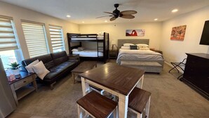 A compact room with a bunk bed, a sofa, a small table, and a TV. - Apartment #3 GREAT LOCATION Zion National Park entrance as close as you can get! (Springdale)
