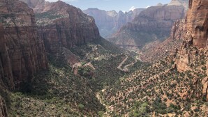 A canyon with rugged cliffs and a winding road. - Apartment #3 GREAT LOCATION Zion National Park entrance as close as you can get! (Springdale)