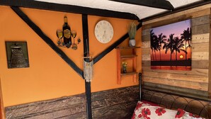 A bedroom with a bed, a clock, a wall-mounted shelf with a vase, and a sunset view through a window. - The Paddock - Sleeping 2 - B & B Yarm double bed en suite /fridge/microwave  (High Leven)