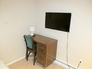 A small room with a desk, chair, and a wall-mounted TV. - Studio apartment close to Notre Dame (1309. 4) (South Bend)