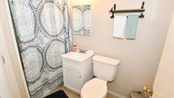 Bathtub, hair dryer, towels, toilet paper