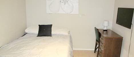 Une chambre à coucher avec un lit, un bureau et une chaise.