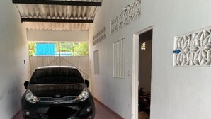 Un automóvil estacionado en un garaje cubierto con piso de baldosas y paneles decorativos en las paredes.