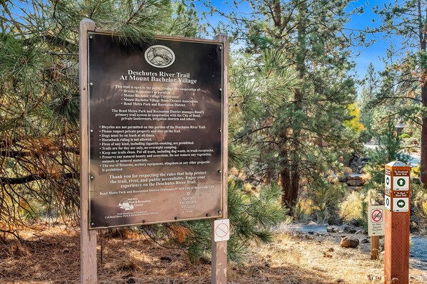 A sign for the Deschutes River Trail at Mount Bachelor Village, listing rules and responsible use guidelines.