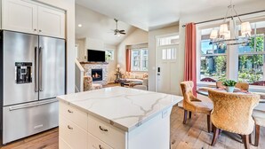 Una cocina amplia con una isla grande, electrodomésticos de acero inoxidable y una chimenea.