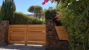 A wooden gate with stone pillars, surrounded by lush greenery and a clear blue sky. - Villa in St-Raphaël with private spa, enclosed garden and terrace - 5 min from the beach (Saint-Raphaël)