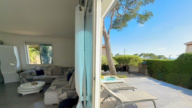 A modern living room with a sofa, a round coffee table, and a hot tub. - Villa in St-Raphaël with private spa, enclosed garden and terrace - 5 min from the beach (Saint-Raphaël)