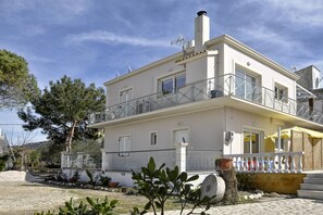 Stylish two-story residence with a balcony and garden views.