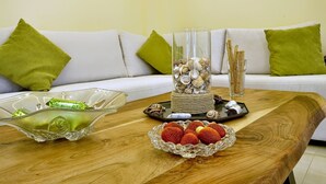 Ein Holztisch mit einer Glasbowl, einer Schale mit Pralinen und einer Glasvase mit Dekoration.