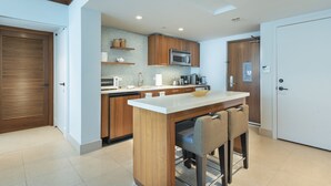 A modern kitchen with wooden cabinets, a microwave, and a white countertop. - Large 2 BR 2 BA Apartment at The Carillon Wellness Resort (Miami Beach)