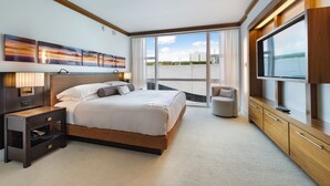A modern hotel room with a large bed, a TV, a desk, and a view of the city. - Large 2 BR 2 BA Apartment at The Carillon Wellness Resort (Miami Beach)