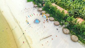 Aan een privéstrand, wit zand, ligstoelen, parasols