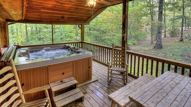 A wooden deck with a hot tub, wooden benches, and a table. - 4WD / AWD Adventure For 2 - Private Setting Near Great Smoky Mtns National Park (Sevierville)