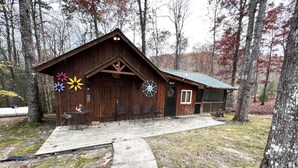 A rustic cabin with a wooden exterior, a porch with chairs, and a decorative wreath on the door. - 4WD / AWD Adventure For 2 - Private Setting Near Great Smoky Mtns National Park (Sevierville)