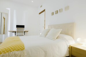 A bedroom with a large bed, bedside tables, a desk, and a mirror. - Luxurious apartment of 130 sqm completely refurbished and equipped for mid to long term stays. (Madrid)