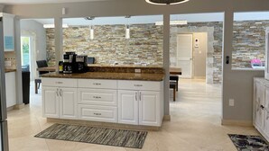 A modern kitchen with a central island, white cabinetry, and a stone backsplash. - ASK ABOUT Sept-Oct2026 SPECIAL! 14Bd10Bth Home Comfortably Accommodates Up to 30 (Marathon)