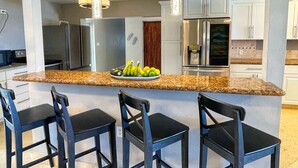 A kitchen with granite countertops, stainless steel appliances, and black bar stools. - ASK ABOUT Sept-Oct2026 SPECIAL! 14Bd10Bth Home Comfortably Accommodates Up to 30 (Marathon)