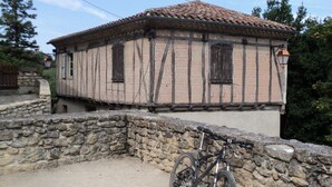 Ein traditionelles Fachwerkhäuschen mit Mauerwerk und einem Fahrrad davor.