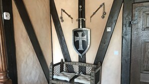 A room with a wooden bench, a shield with a cross, and a door with a metal latch. - Interesting holiday apartment GUARDROOM in the Leppersdorf manor (Wachau)