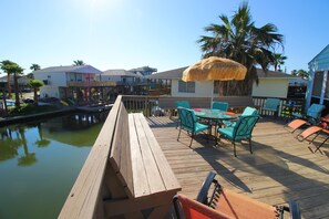 Relax on the deck overlooking the marina, surrounded by palm trees and scenic views.