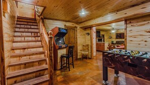 A wooden interior with a staircase, a foosball table, and a small kitchen area. - At Last, you can enjoy life with all the comforts of your own home on your stres (Broken Bow)
