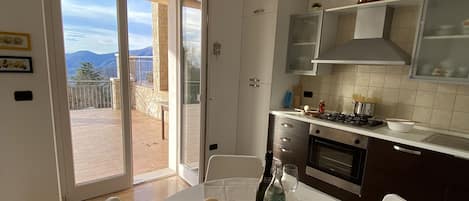 Enjoy meals with a view of the mountains from this kitchen's dining area, which features a stainless steel range hood and a large window.