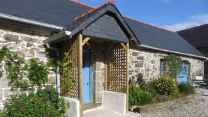 A stone building with a wooden porch and a blue door.