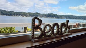 Una ventana con vistas a un lago y un letrero de madera que dice "Beoch".