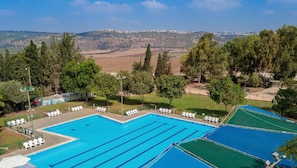 Piscine extérieure en saison, parasols, chaises longues