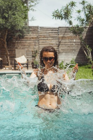 A person in a swimming pool with splashing water. - Maison d'hôtes La Domitia (Montbazin)