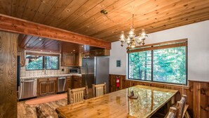 A spacious kitchen with wooden cabinetry, stainless steel appliances, and a large island with chairs.