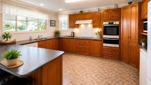 Una cocina con armarios de madera, encimera de granito y suelo de baldosas.
