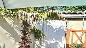 A stone pathway leading to a wooden gate, surrounded by rocks and plants. - house for rent. (Caumont-sur-Durance)