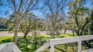 A view of a park with a gazebo, trees, and a playground.