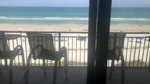 A balcony with chairs overlooking a beach. - Oceanfront  Sandcastle Condo, South #506 (Ponce Inlet)
