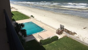 A beachfront hotel with a swimming pool, a sandy beach, and ocean views. - Oceanfront  Sandcastle Condo, South #506 (Ponce Inlet)