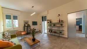 A modern living room with a sofa, a coffee table, and a bookshelf. - Entire apartment on the first floor (Piumazzo)